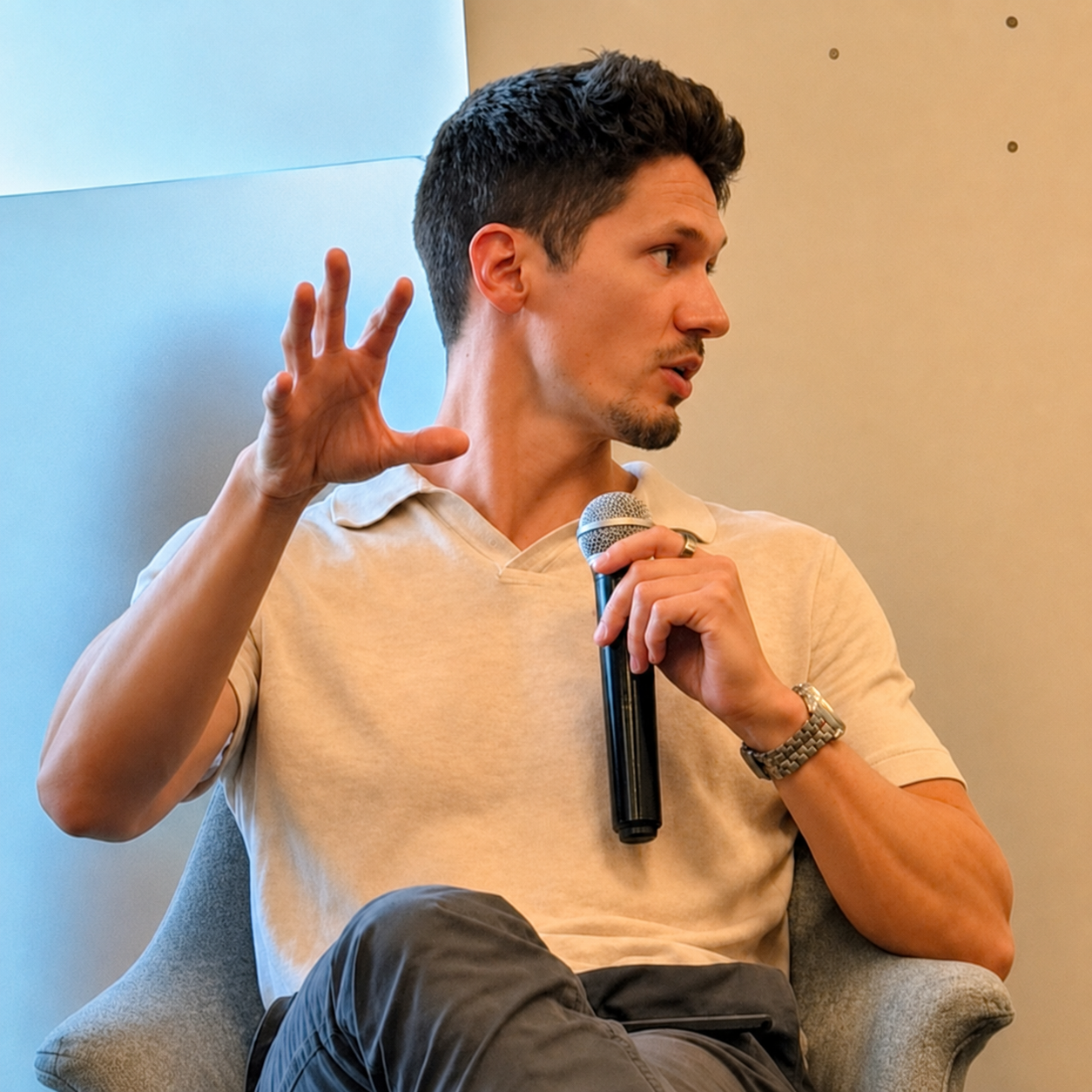 Alex Constantin speaking on a panel, mid-sentence